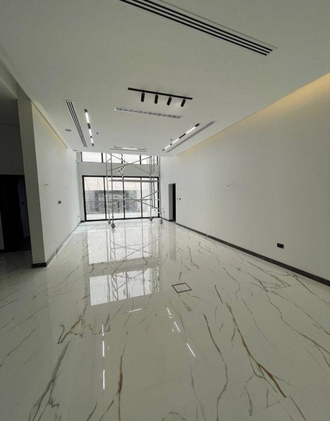 Double-height living hall with book-matched marble floor.
