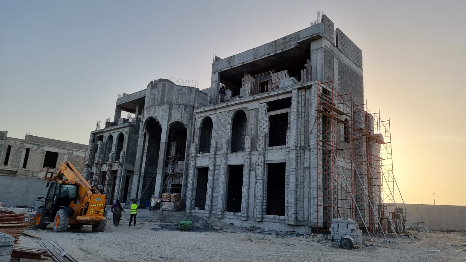 Mansion structure under construction in Al Shamkha at golden hour.