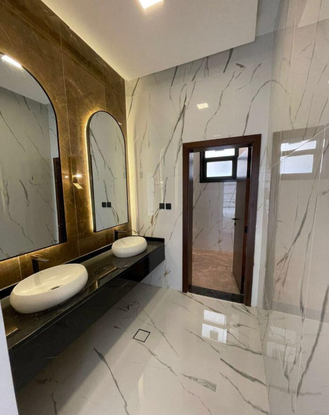 Gold-arched double vanity in book-matched marble, Al Helia